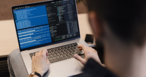 close-up-man-writing-code-laptop-about-co-employment