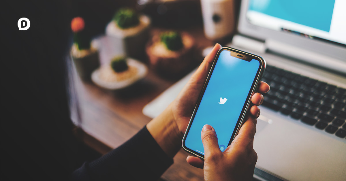 woman holding smartphone with twitter app