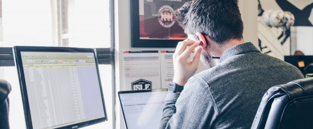 Homem com fones de ouvido sentado na frente de seu computador