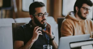 AI Hallucinations: man wearing eyeglasses and headphones beside smiling man Party Sami from the Unsplash Team working away, with a side helping of ‘le Phantom’ Tim Bones