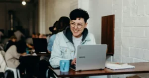 Cloud Models: smiling man sitting and using Samsung laptop near people