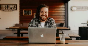 Cost-Effective Hiring: man in black and white striped polo shirt sitting on chair in front of silver macbook