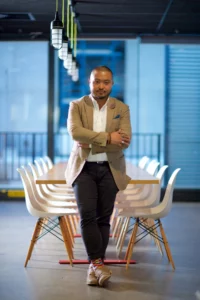 founders and c-level executives: Startup founder leans in front of long meeting table. 