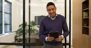 hidden staffing costs: a man standing in an office looking at a tablet