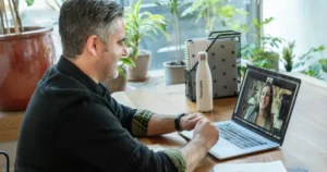 questions to ask candidates: man in black sweater using macbook pro working in an office on a virtual call