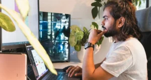 remote work setup: young software engineer with a man looks attentively at the screen